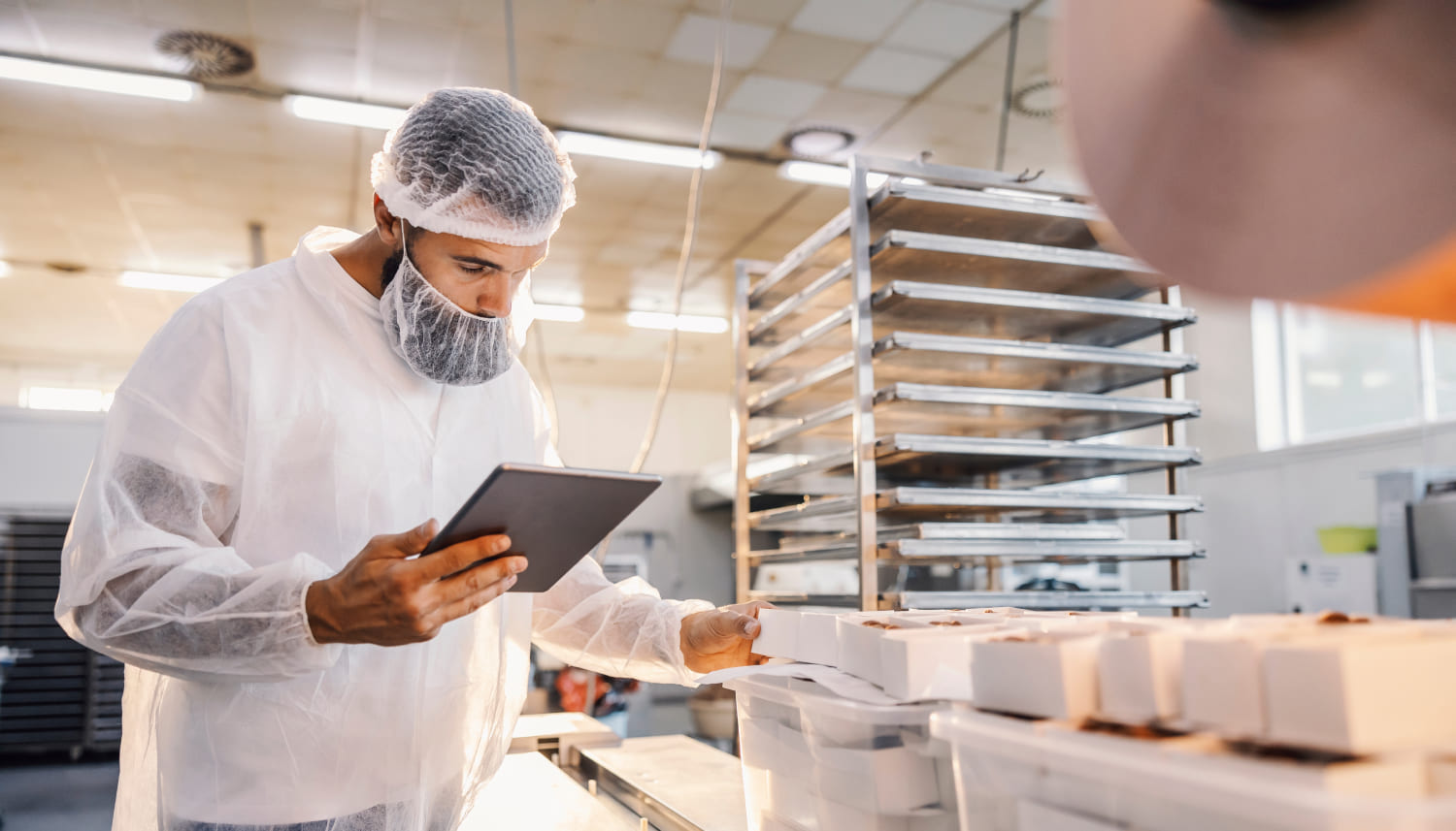 タブレットを用いた食品工場の監督者で、食品の品質を評価する