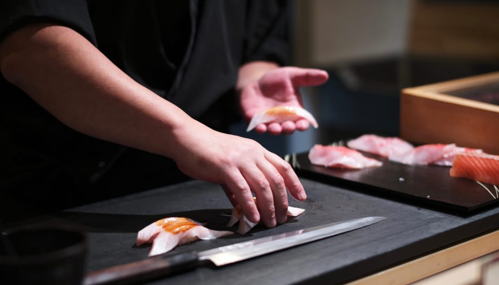 お皿に寿司を持っている寿司職人