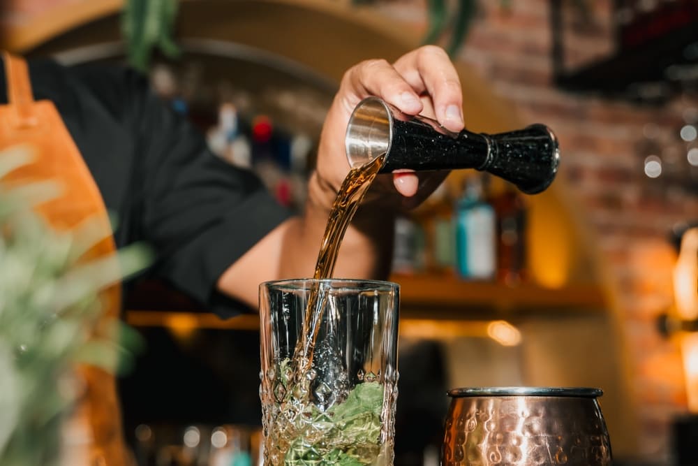 シェイクしたカクテルをグラスに注ぐバーテンダー