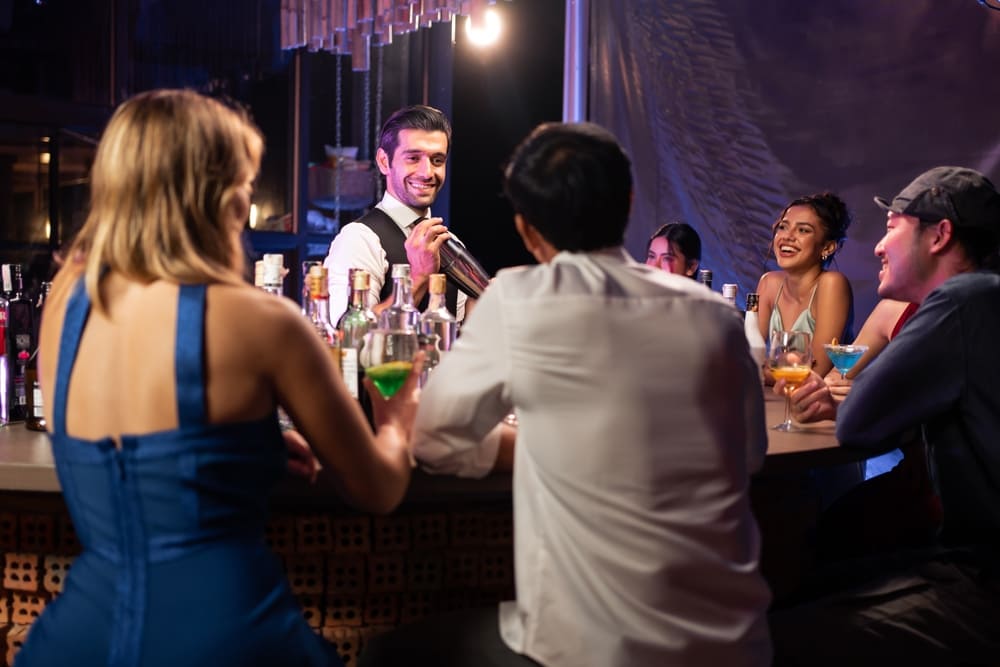 多数のお客さんと盛り上がる笑顔のバーテンダー