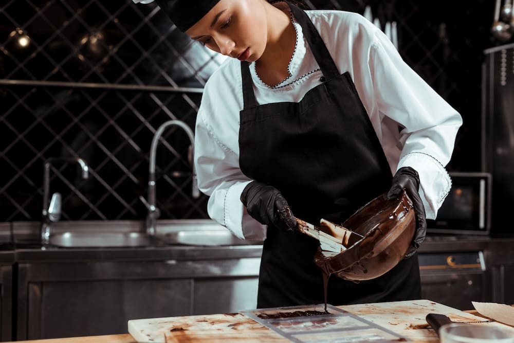 液状のチョコレートを型に流す女性
