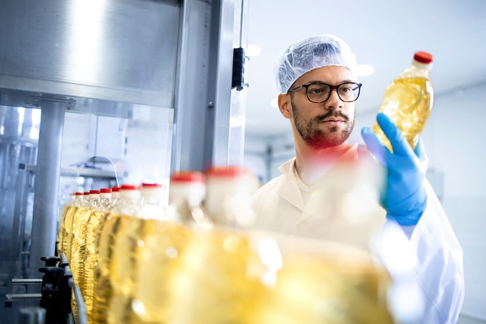 レーンで作られた飲み物を検査する男性作業員