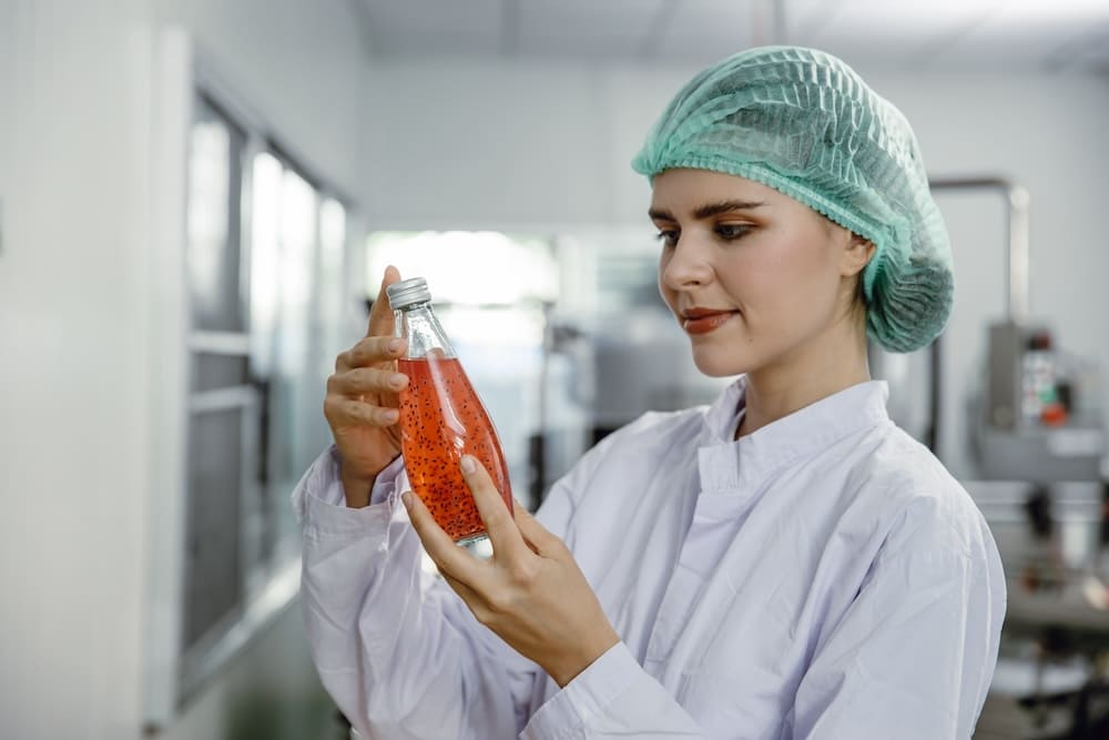 瓶詰めされた飲み物を調べる研究員