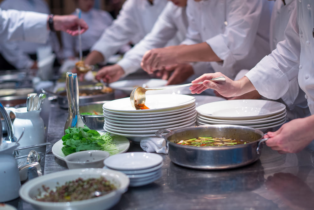 お皿に料理を盛り付ける男性シェフ達