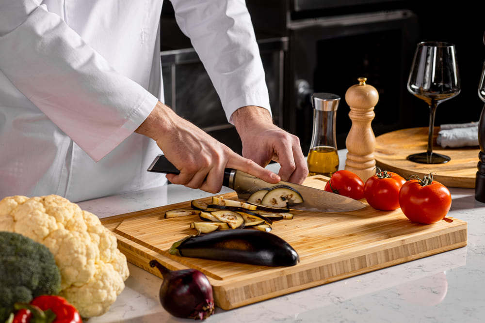 まな板で野菜をカットする男性シェフ