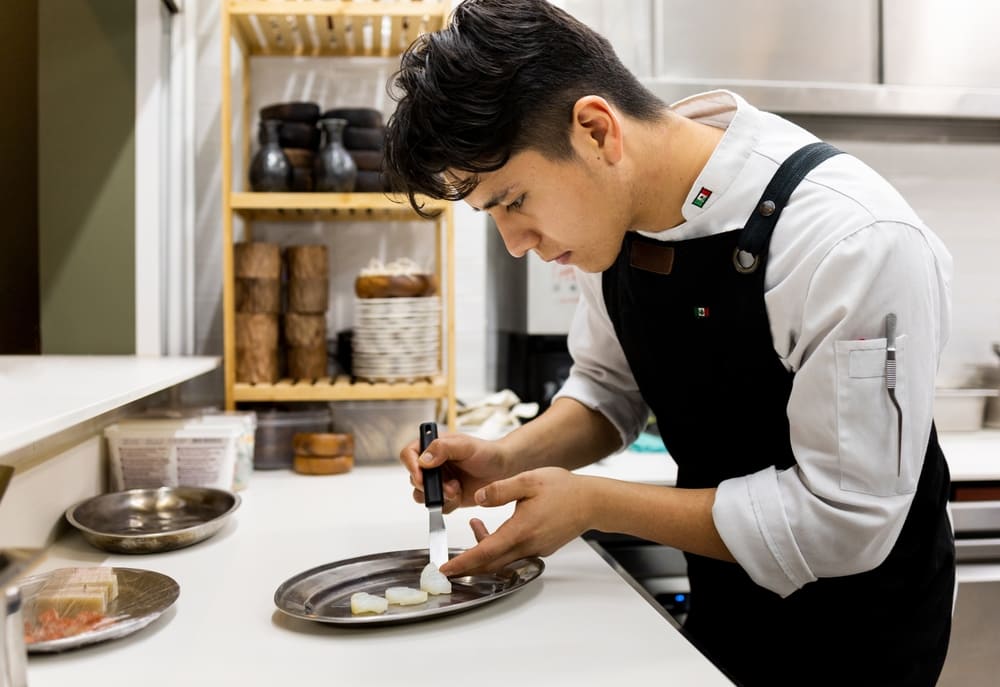 料理を盛り付ける男性料理人