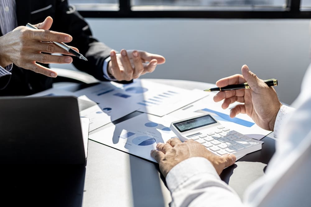 書類を見ながら打ち合わせをするスーツを着た男性