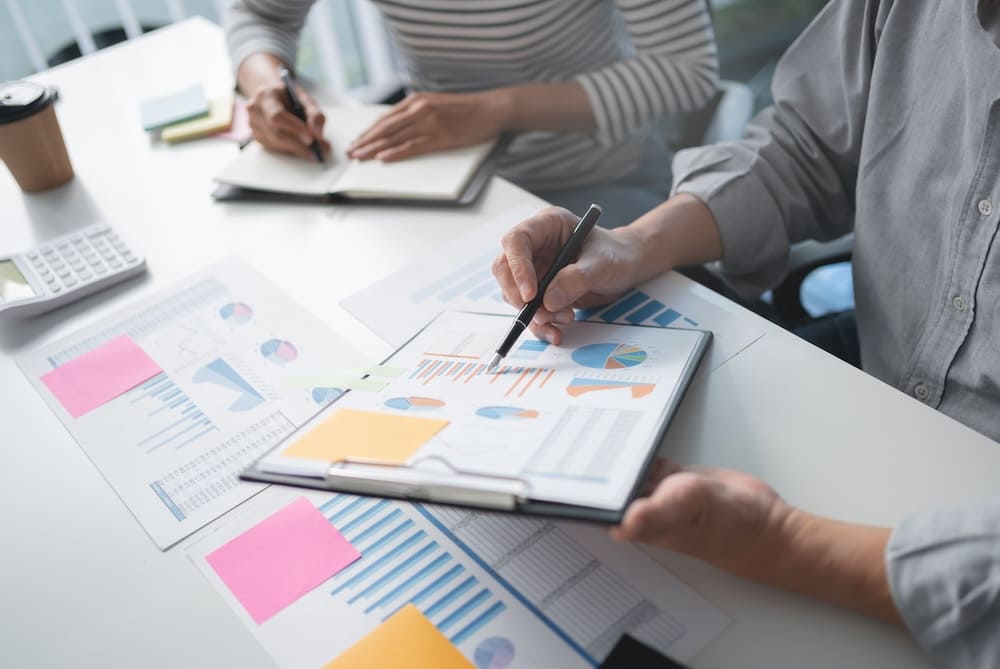 グラフを見ながら打ち合わせをする男性と女性