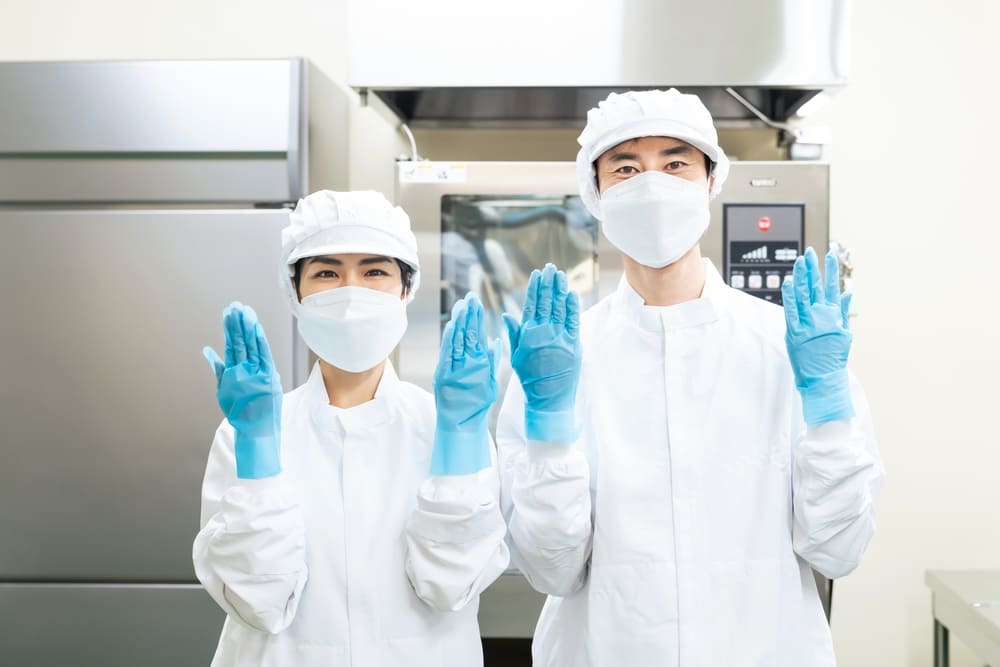 全身白衣とマスク・手袋・帽子をつけた男女