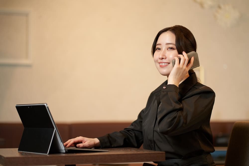 タブレットを見ながら電話をする女性