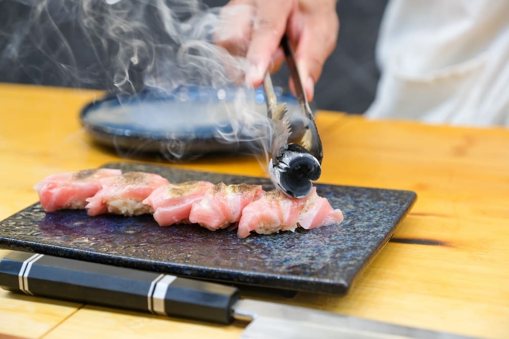 焼石をお寿司に当てる料理人
