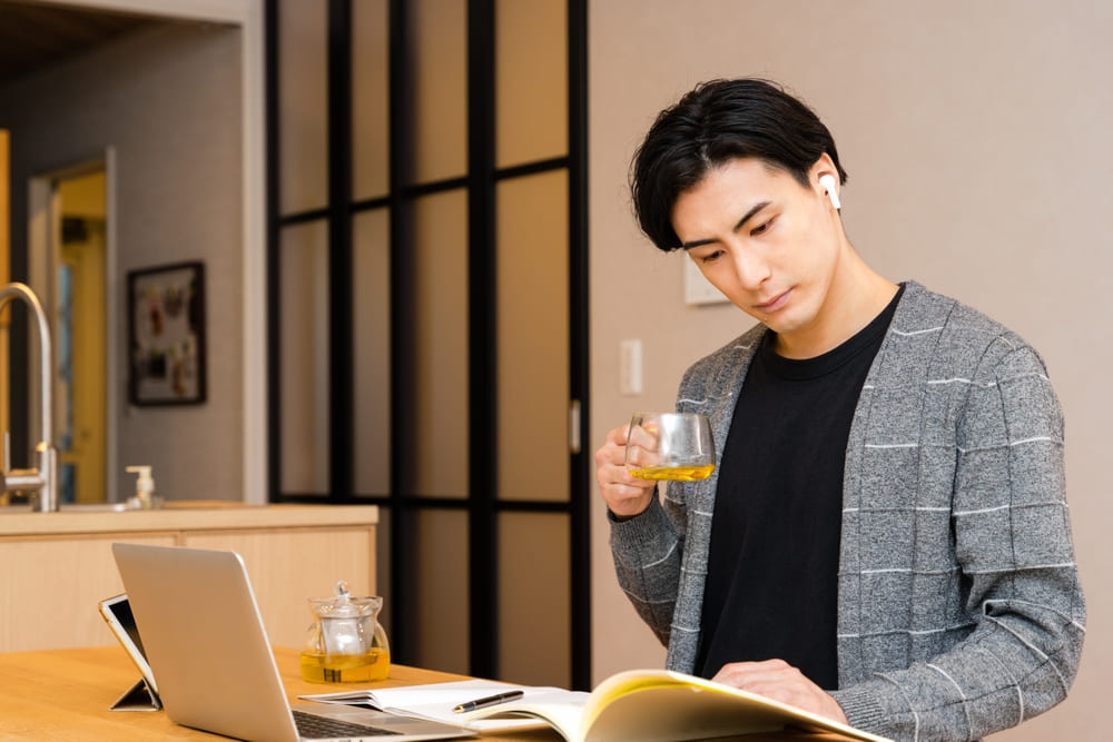 パソコンと本を使って勉強する男性