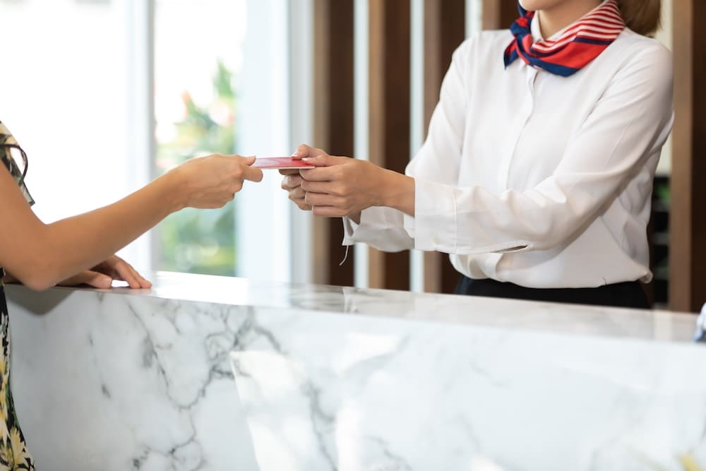 カードをお客に渡している受付の女性
