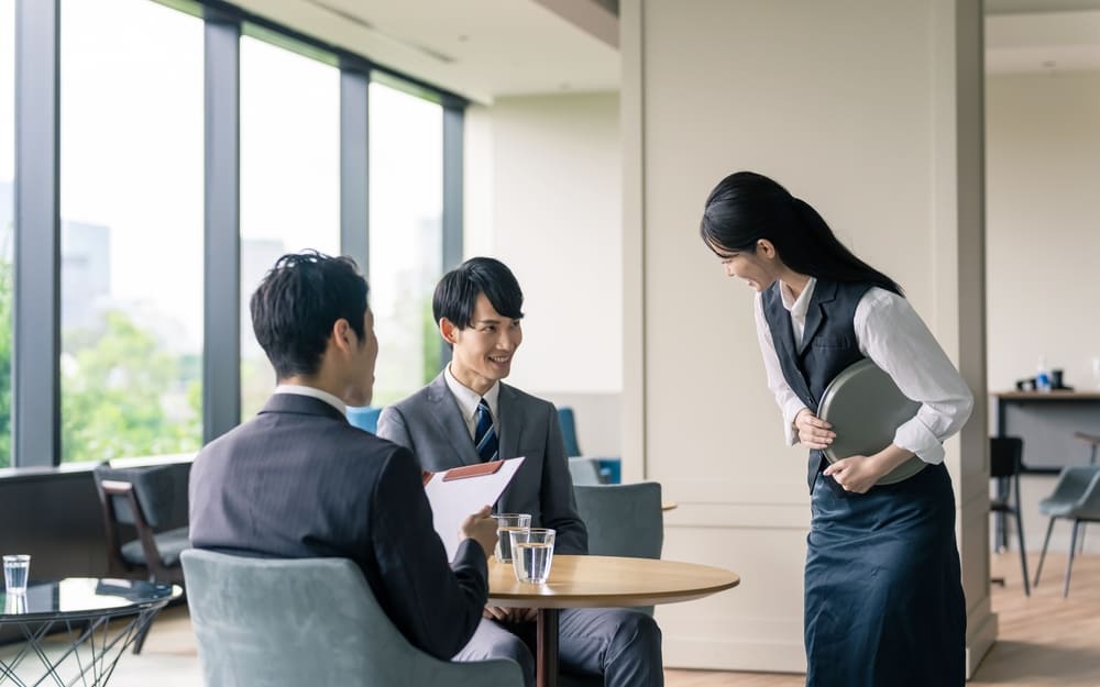 スーツを着た男性に接客をする女性