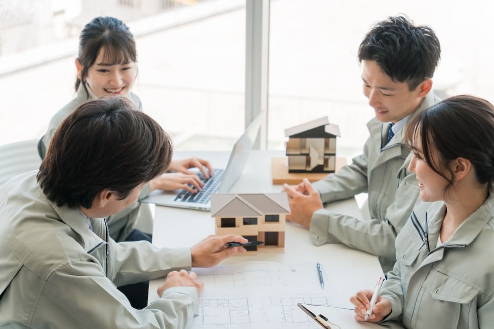 間取りを打ち合わせする作業服をきた複数の男性と女性