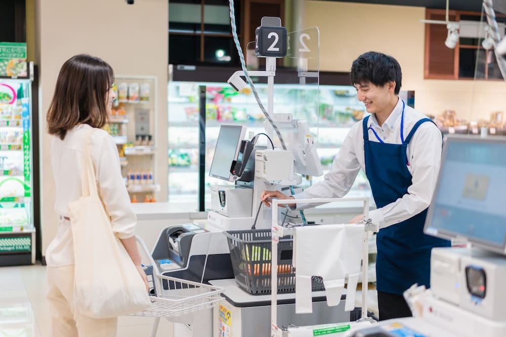 レジを打つ男性の店員と会計を待つ女性