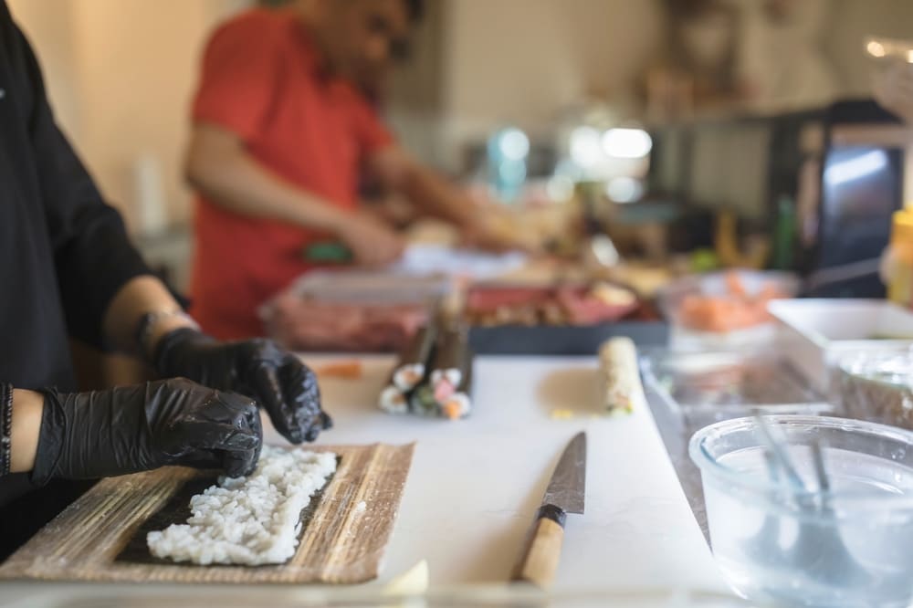 海苔で寿司を巻く外国の寿司職人