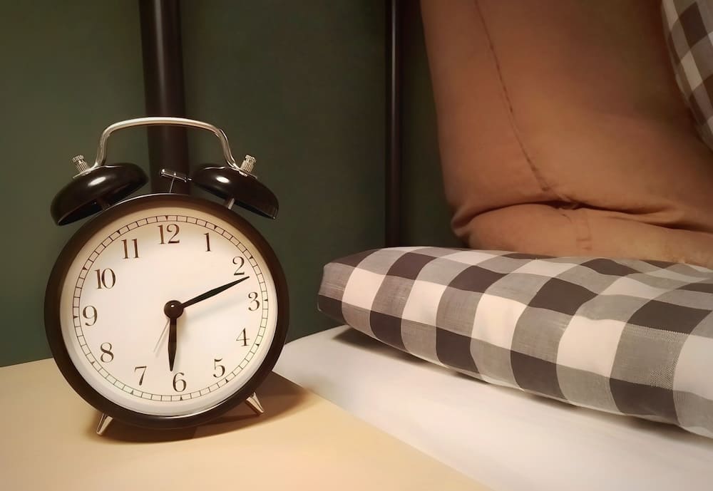 枕元に置かれた目覚まし時計