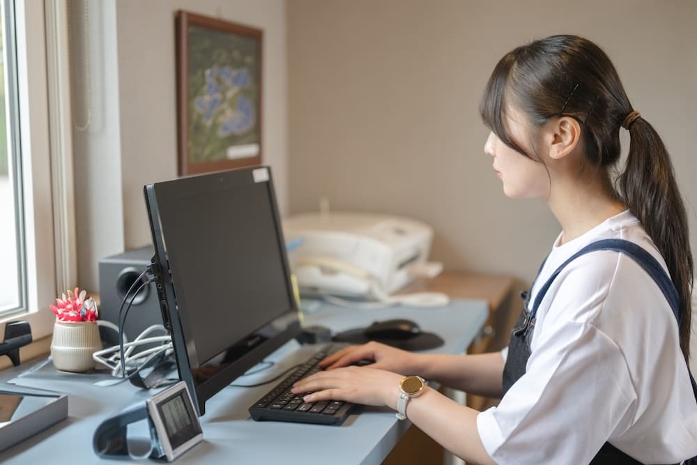 パソコンを操作するエプロンを着た女性店員