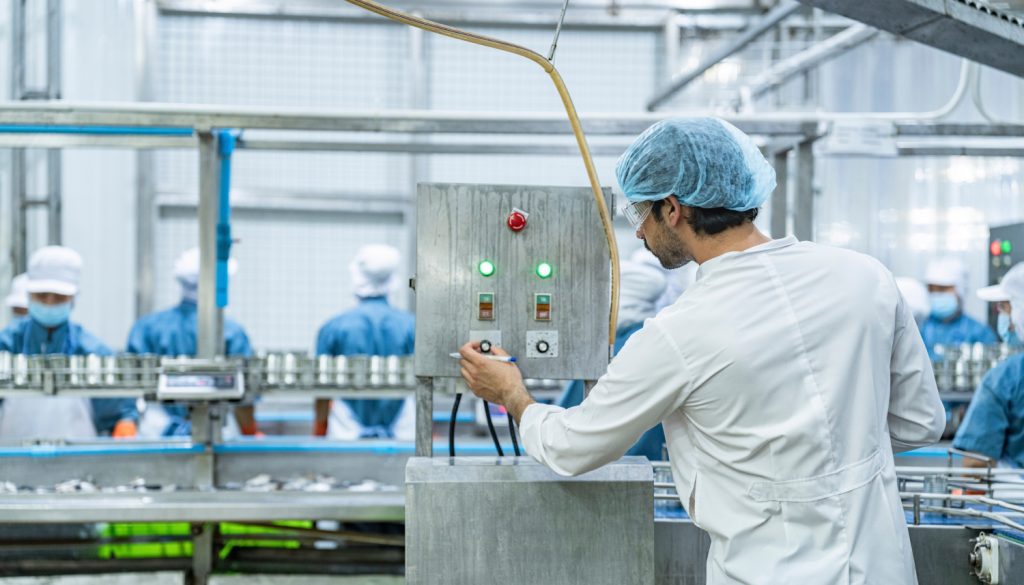 食品工場で機械を操作する男性