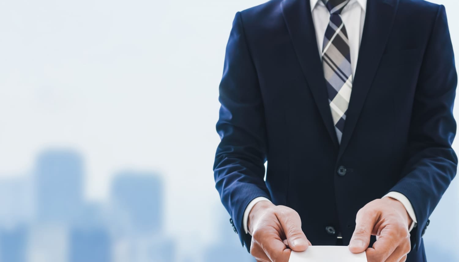 名刺を渡す紺色スーツの男性