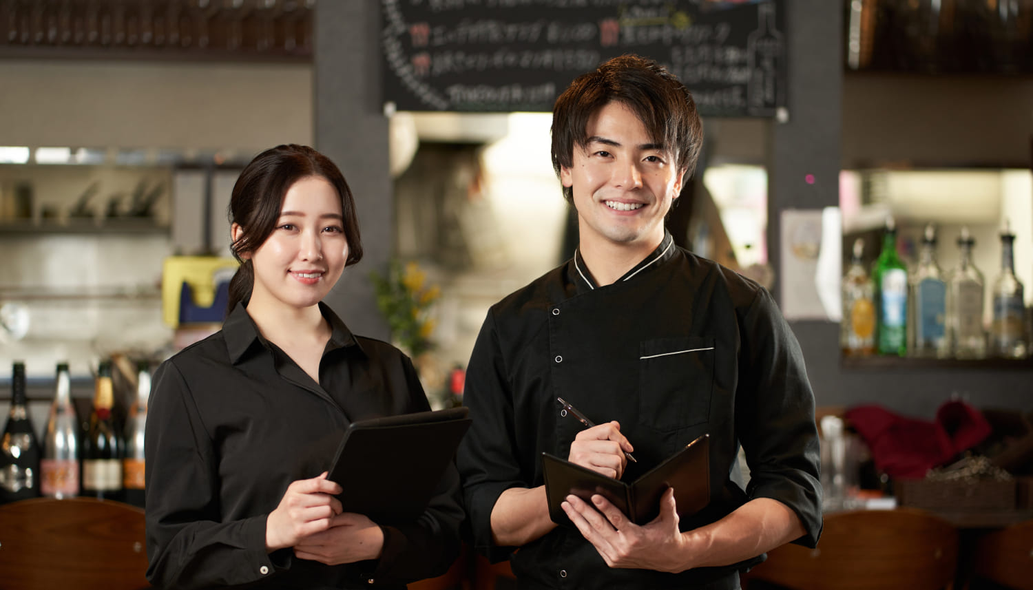 黒い制服を着た男性シェフと女性店員