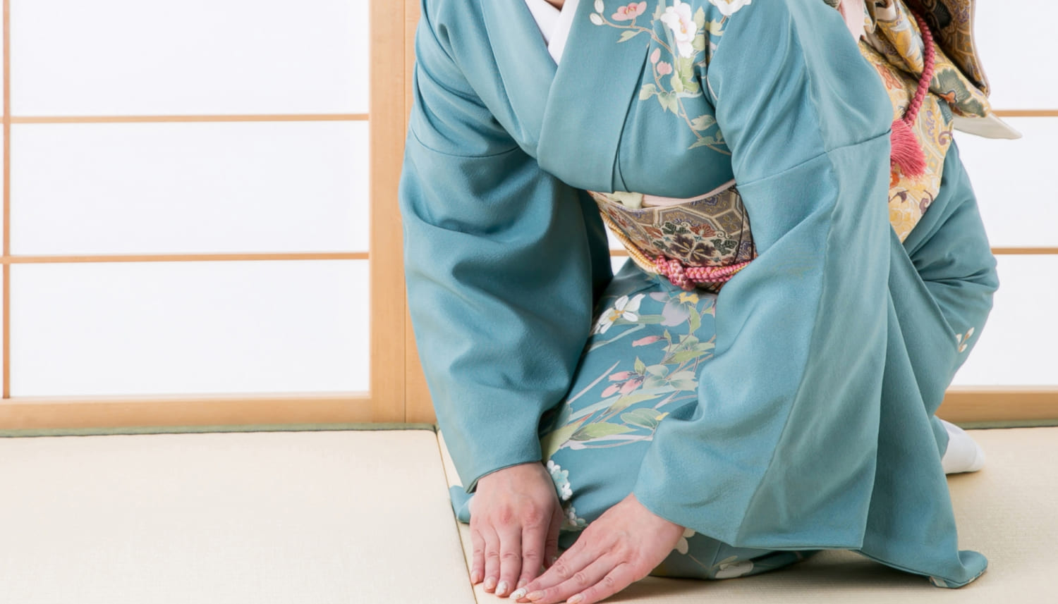 両手をついて挨拶をする着物を着た女性