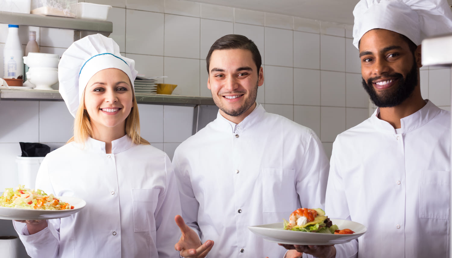 料理を持った2人の男性シェフと1人の女性