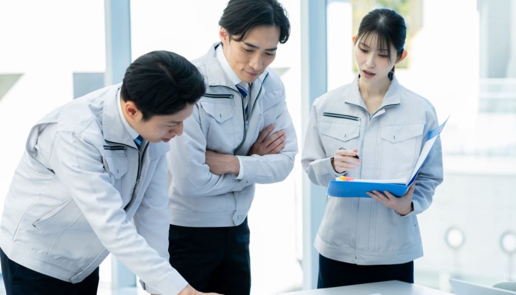 開発の打ち合わせをする男性作業員2人と女性作業員