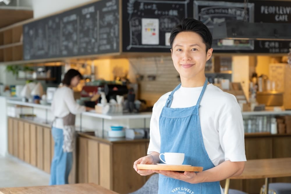 コーヒーを運ぶ男性