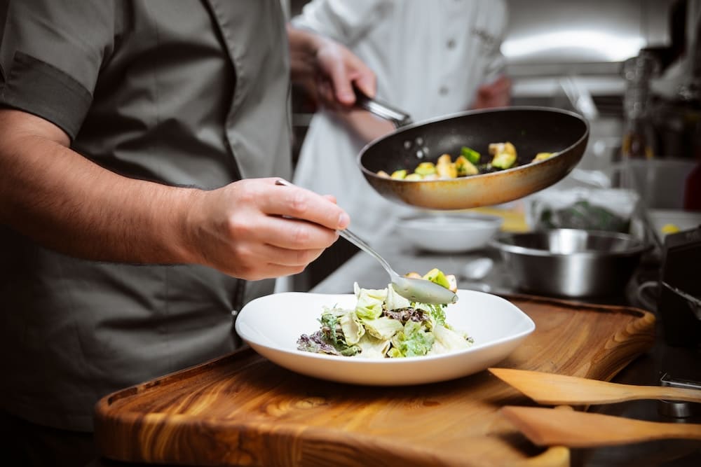 料理を盛り付ける男性の手元