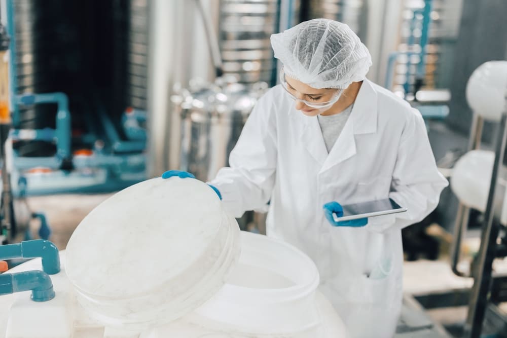 タブレットを持って調査する白衣を着た女性