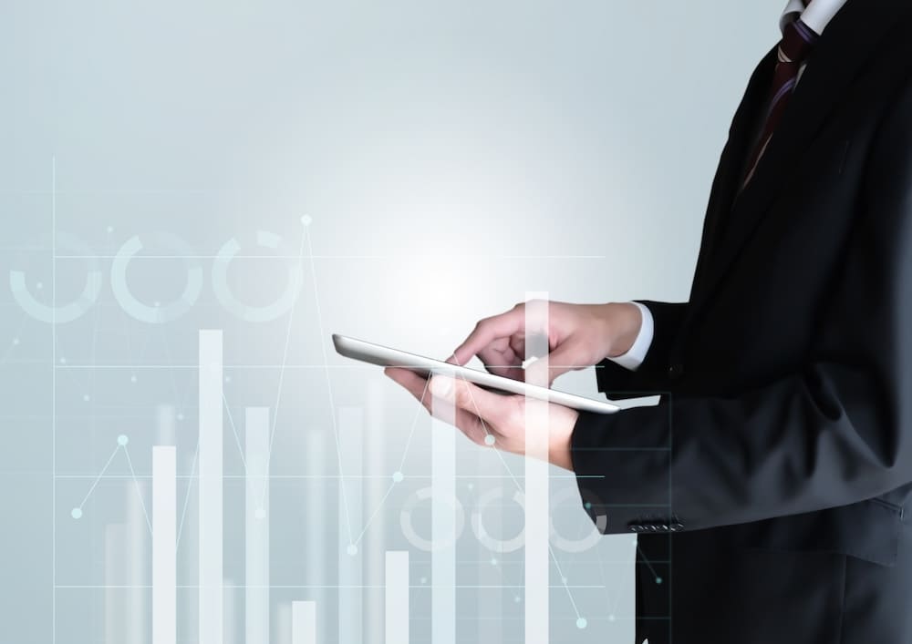 タブレットで数値を調査するスーツを着た男性