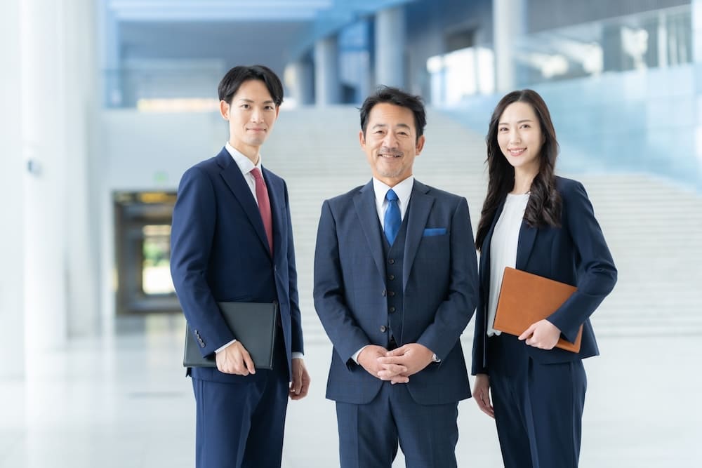 中央に中年の男性と左に若い男性と右に若い女性