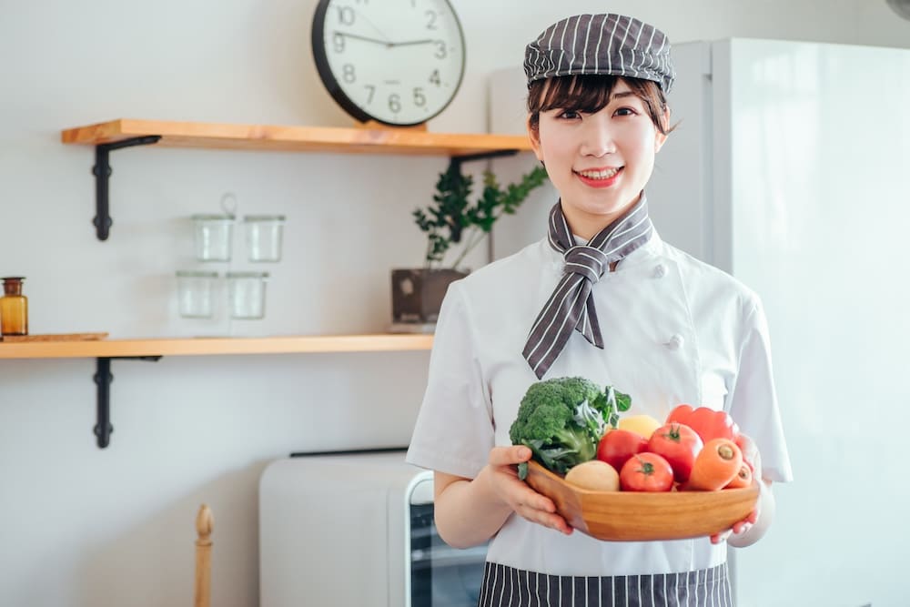 野菜を持った女性の料理人