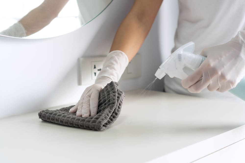 ドレッサーの前を拭き清掃する女性