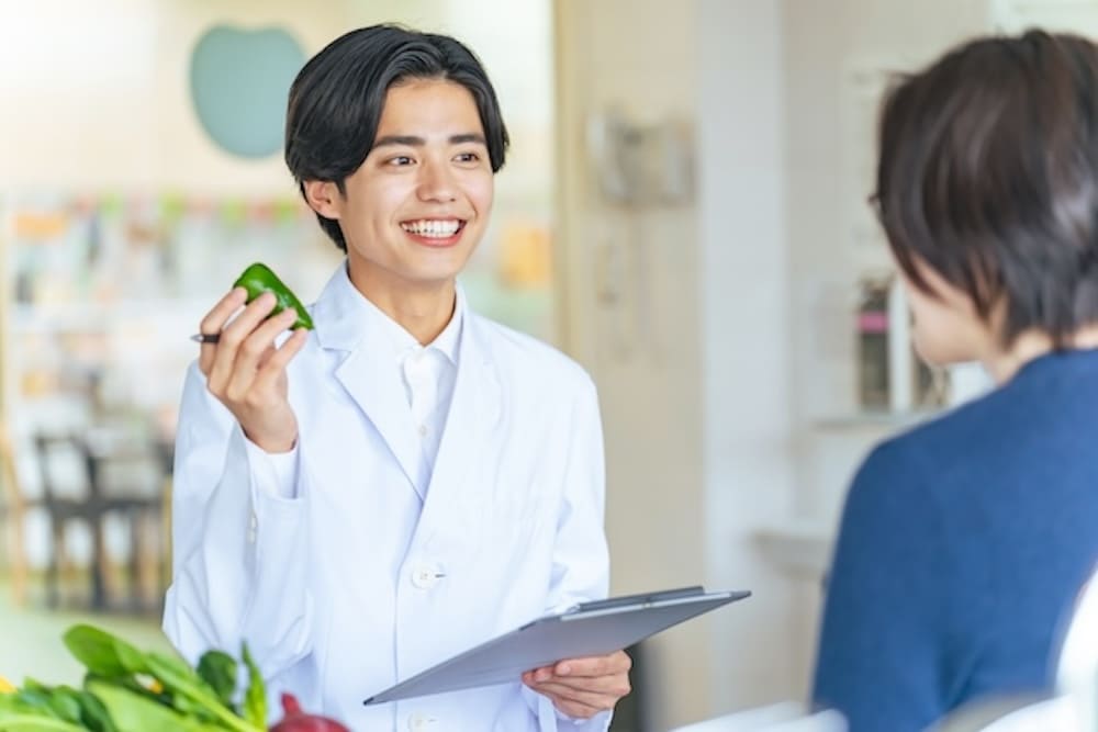 食材のプレゼンをする白衣を着た男性