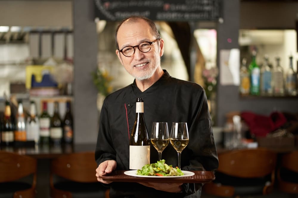 ワインと料理を持つ中年の男性