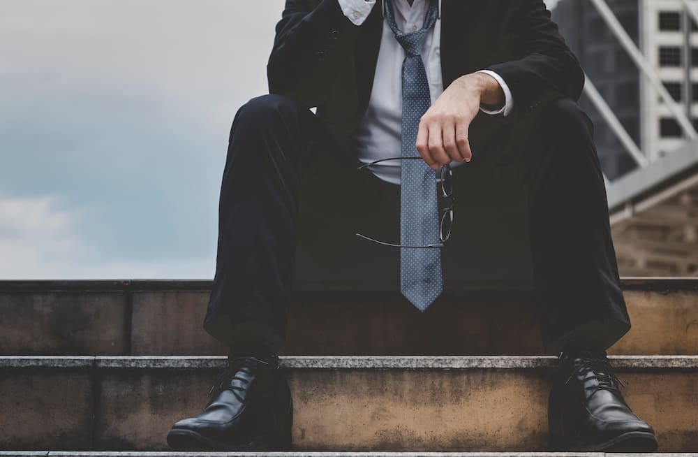 階段に座った悩んでいる男性