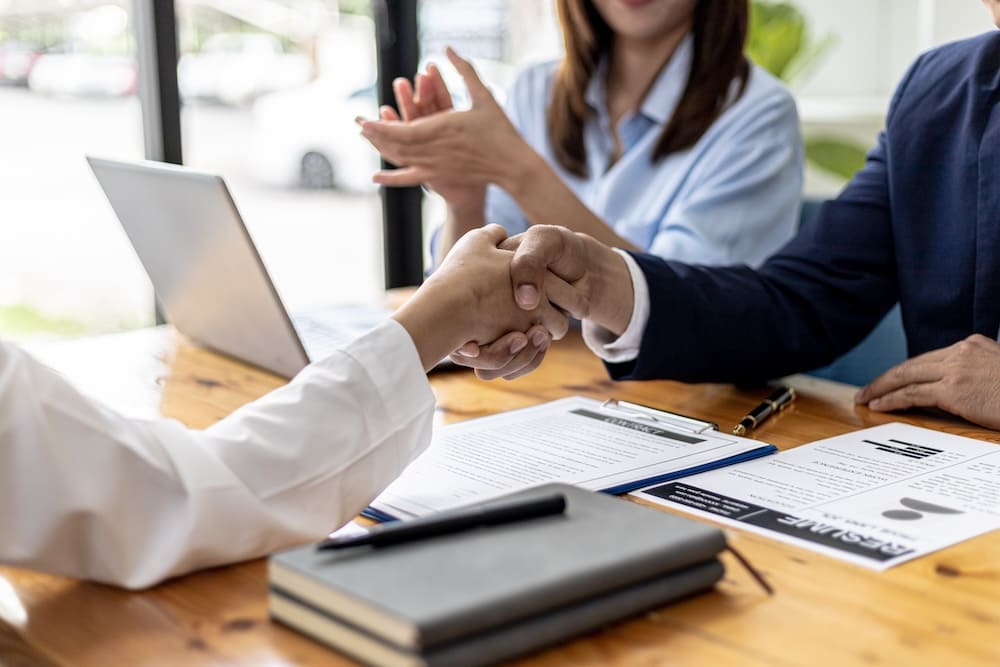 握手をする男性と拍手をする女性