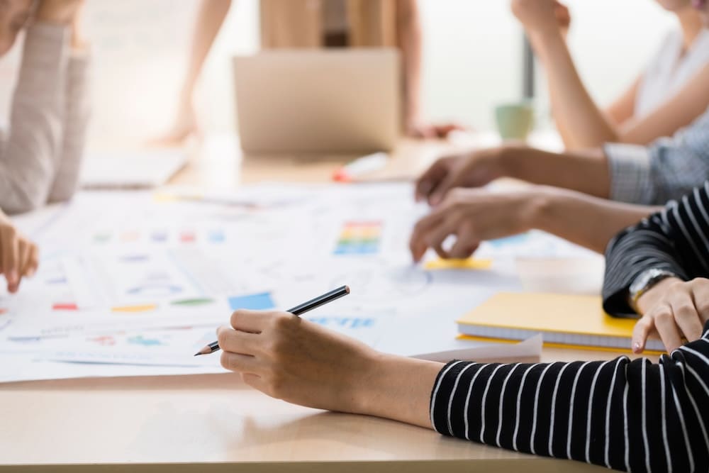 商品開発について紙を使って打ち合わせする男性と女性