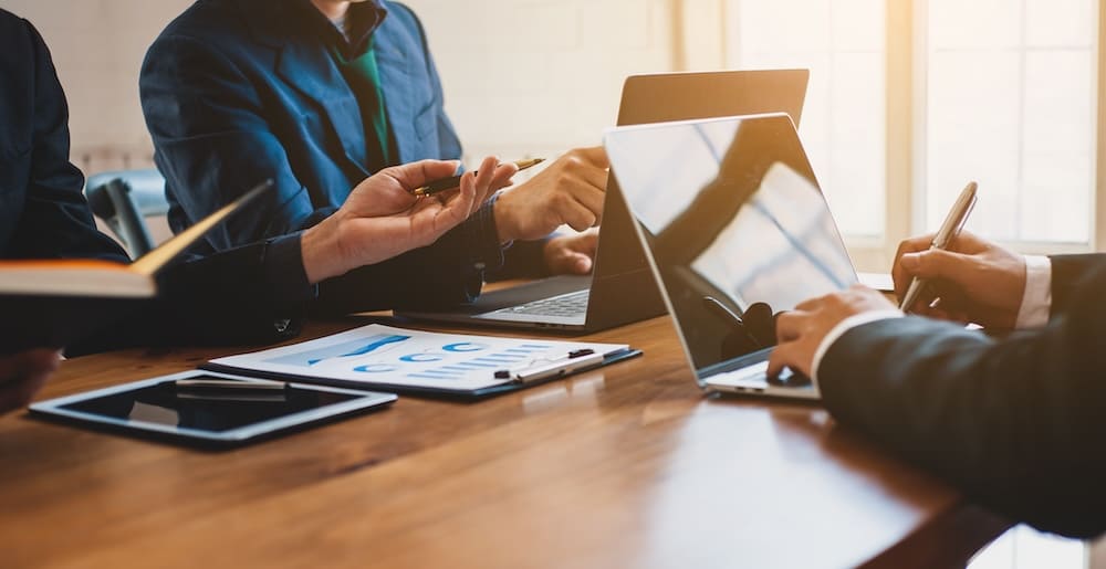 パソコンと書類を使って打ち合わせをする男性と女性の会社員