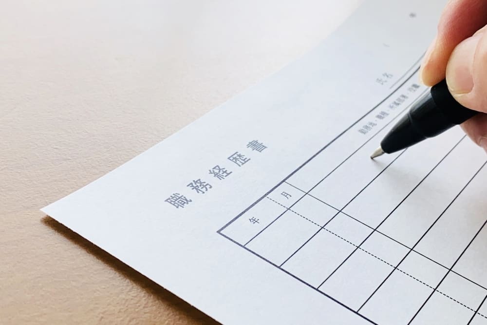 職務経歴書にボールペンを使って記載している