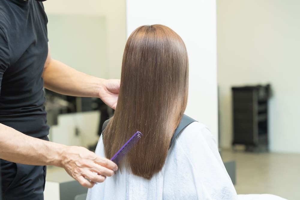 美容室で髪を整える女性