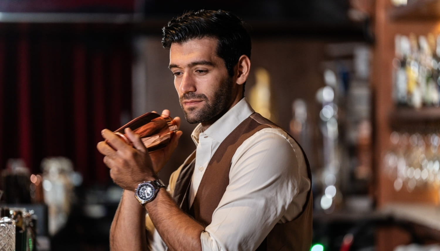 カクテルをシェイクする男性バーテンダー