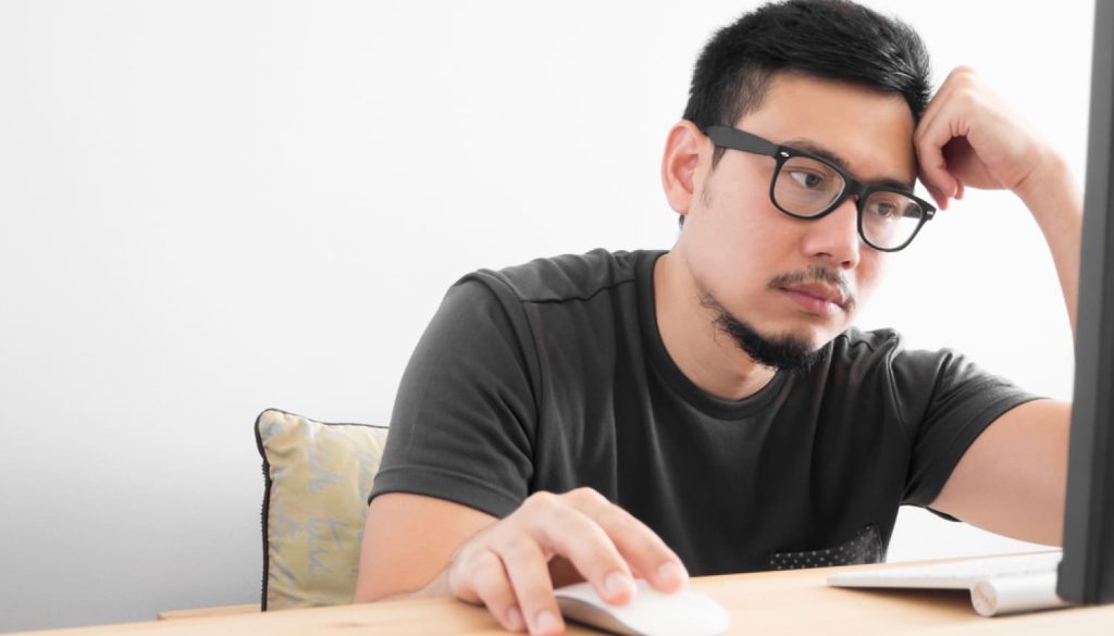 パソコンの前で頭を抱える男性