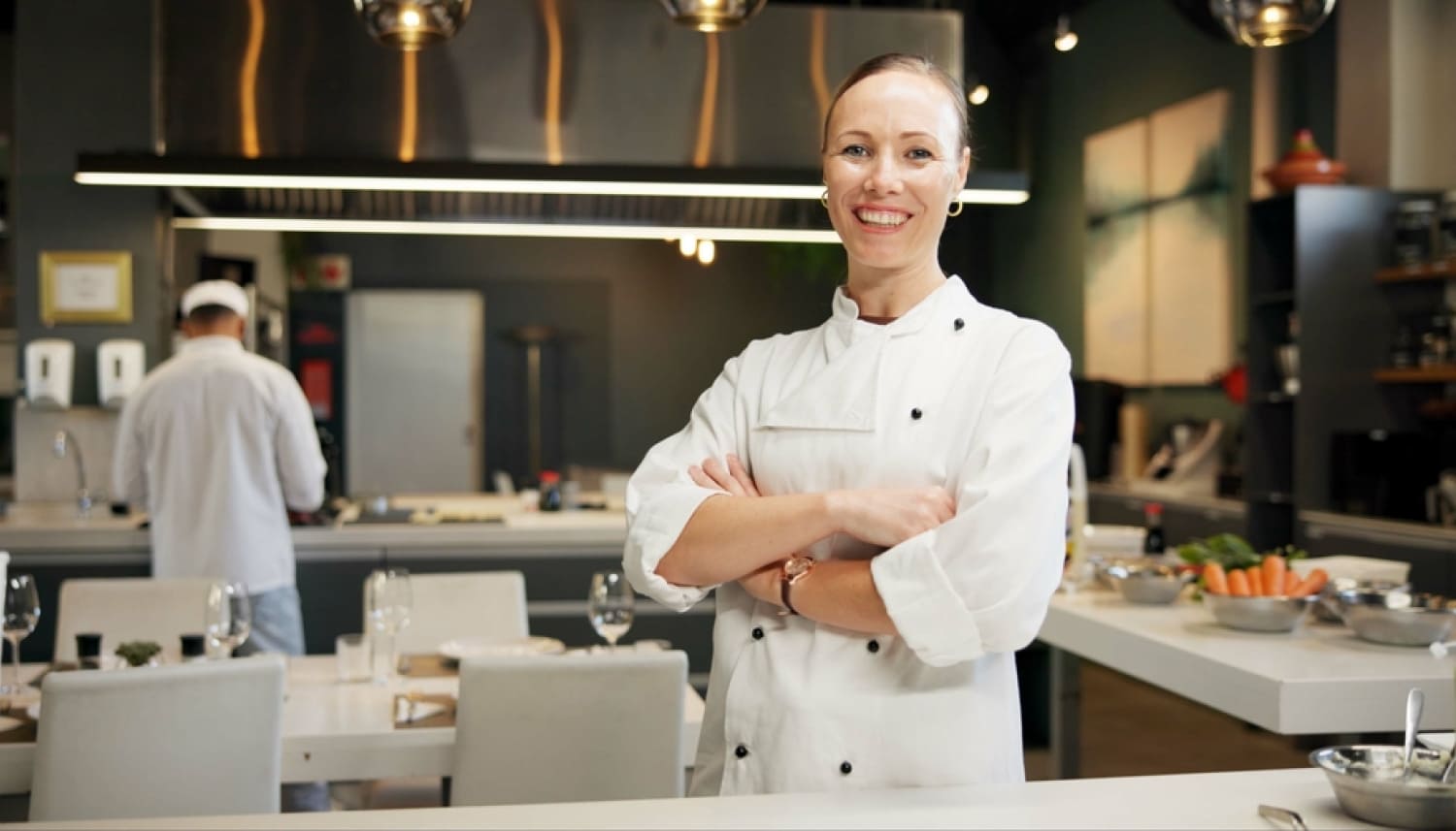 厨房で腕を組む女性料理人