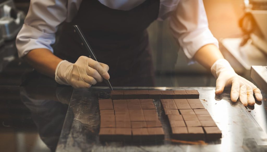 チョコレートをカットするショコラティエ