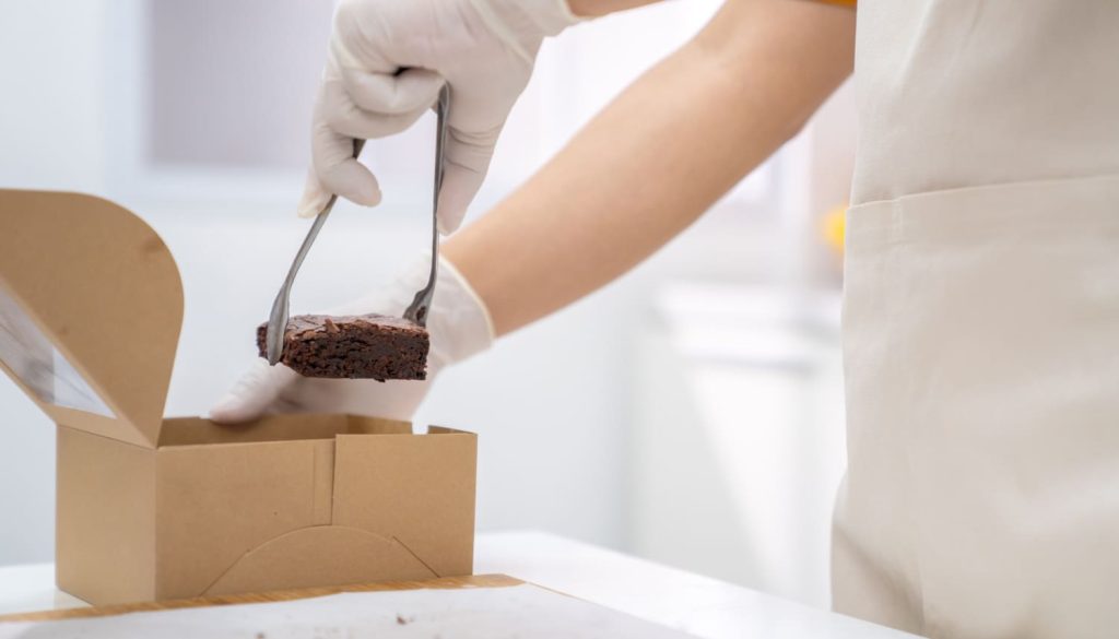 ケーキを箱詰めするパティシエ