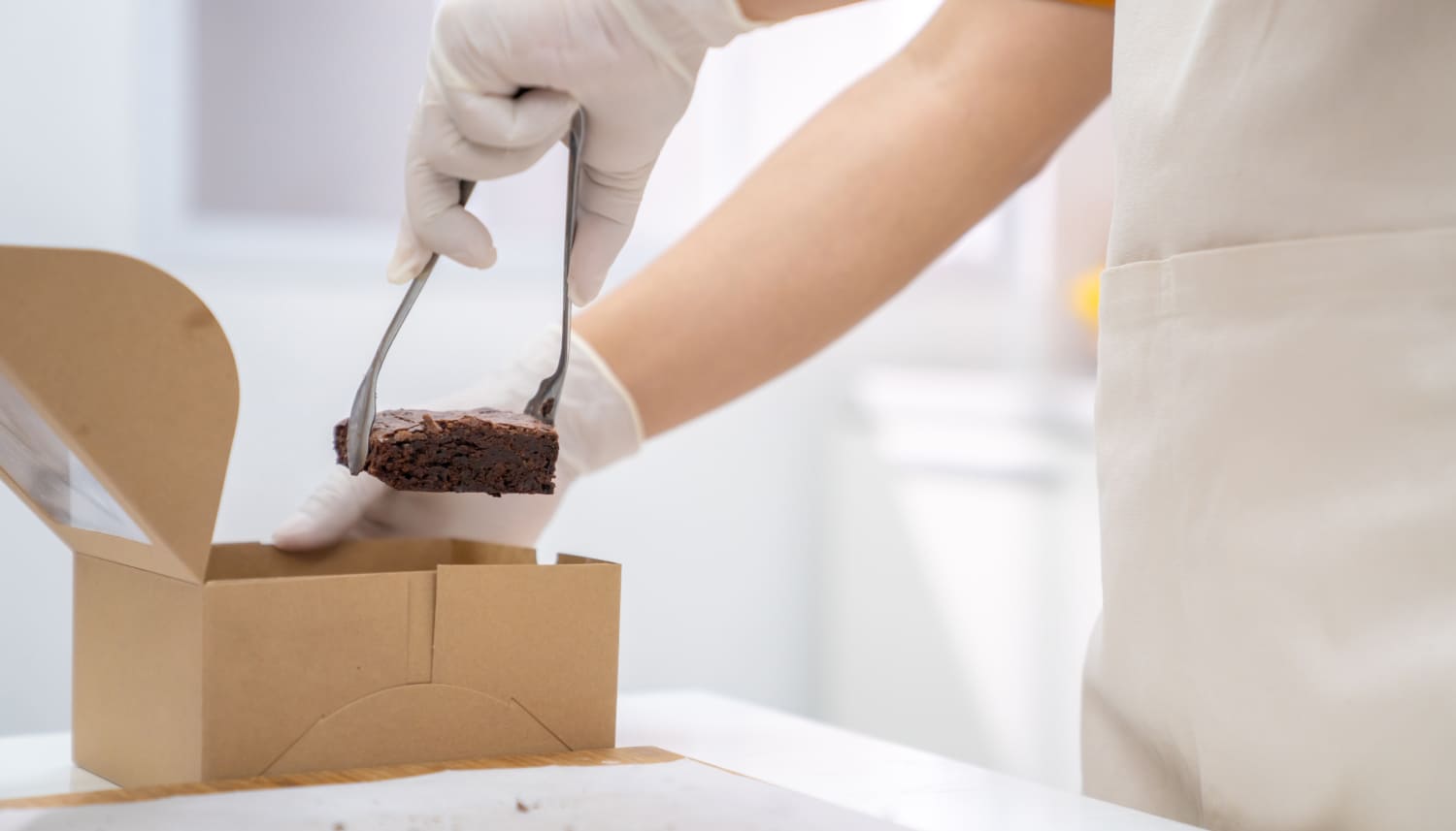 ケーキを箱詰めするパティシエ